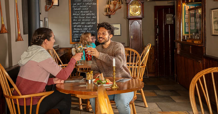 couple eating and clinking glasses together at The Rose and Crown Inn, Romaldkirk, County Durham